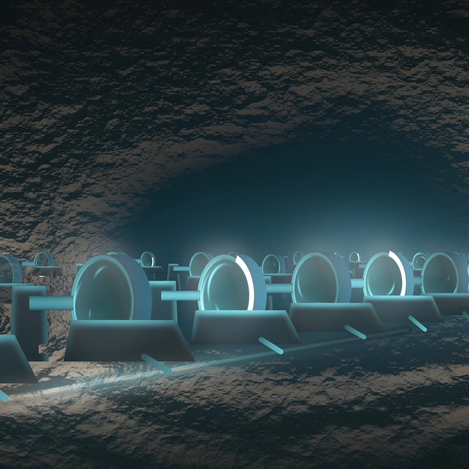 An artistic imagining, not real hardware. A dark cyan scene underground: a rank of heavy composite flywheel drums stands in a rock tunnel on Mars, receding to the right toward a pale glow far down the hall. Each drum is turned away from the viewer, so it reads as a thick ellipse rather than a full circle, and each sits in a low containment cradle with a drive can and a horizontal shaft entering from the left and disappearing behind the wheel. Nothing is drawn at the axis. A bright arc of light wraps part of every rim, long on some wheels and short on others, and the faces carry soft tangential smears where the mass is turning. A lit power line runs along the floor from the lower left, and a short feeder drops from each cradle down onto it. The rock roof and floor are modelled in tone only, warm basalt washed cyan by the machines, with no drawn outline anywhere.
